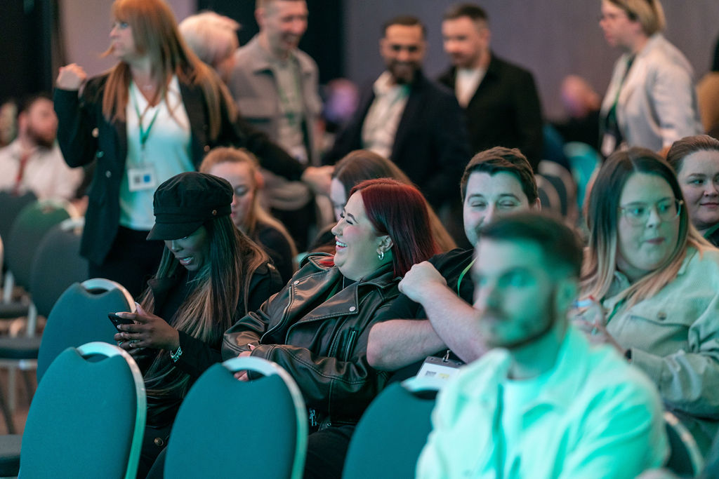 Delegates laughing in the audience between sessions